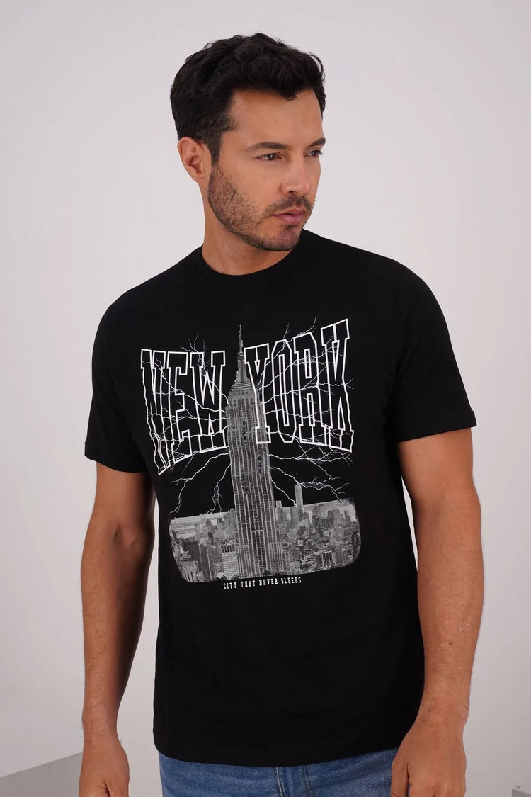 Hombre vistiendo una camiseta negra con diseño de Nueva York, destacando el estilo y confort de los básicos superiores de hombre.