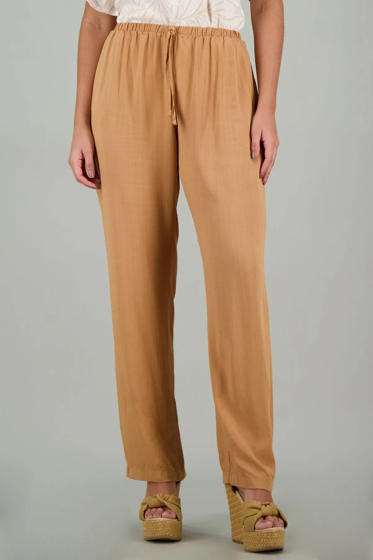 Mujer usando pantalones de tela color beige como parte de su colección de Básicos inferiores de mujer.