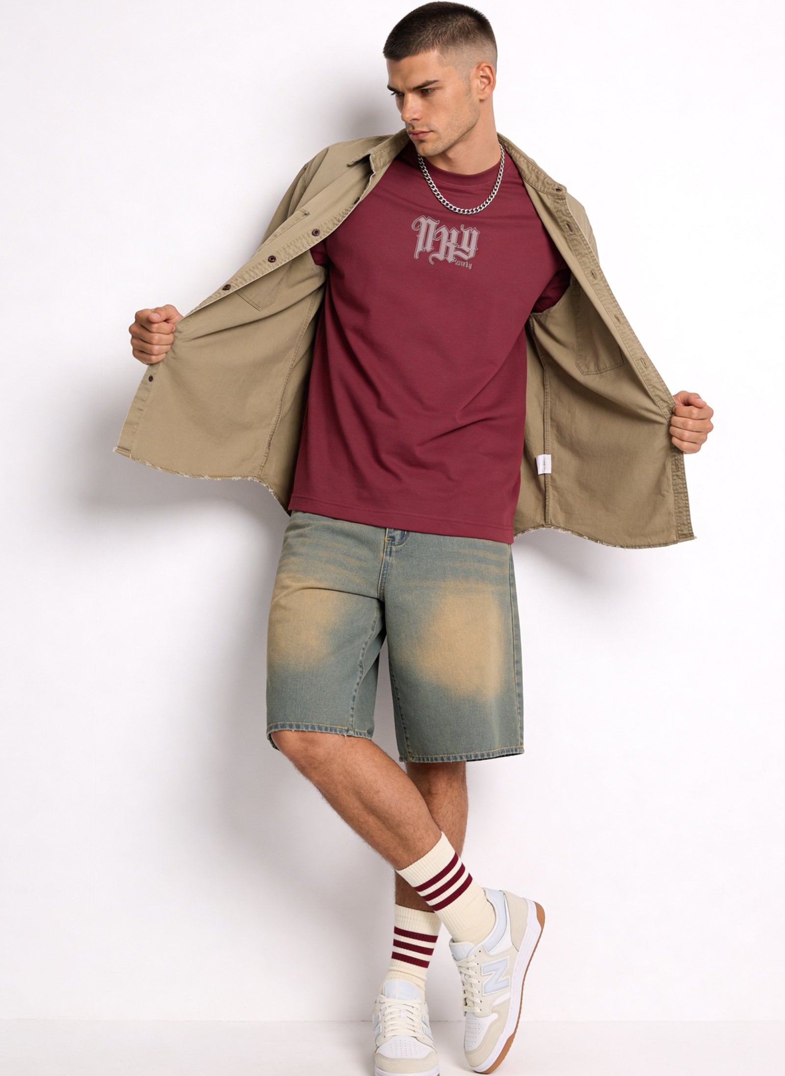 Hombre con camiseta de hombre sublimada en color burdeos, pantalones cortos y calzado deportivo.