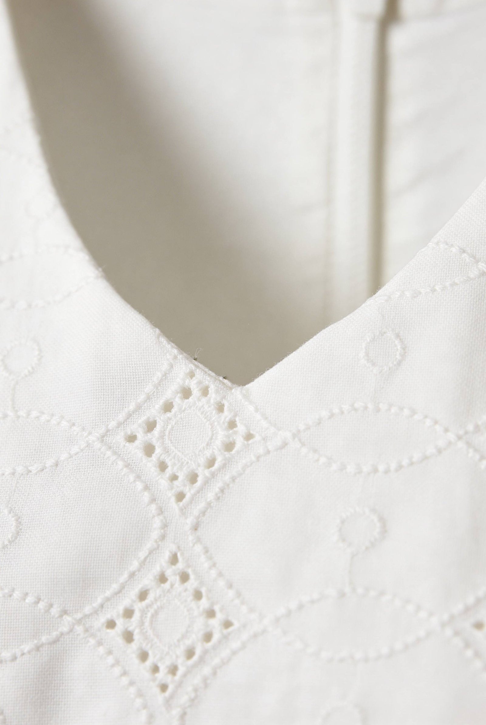 Detalle del escote en un vestido de dama de moda con tejido bordado.