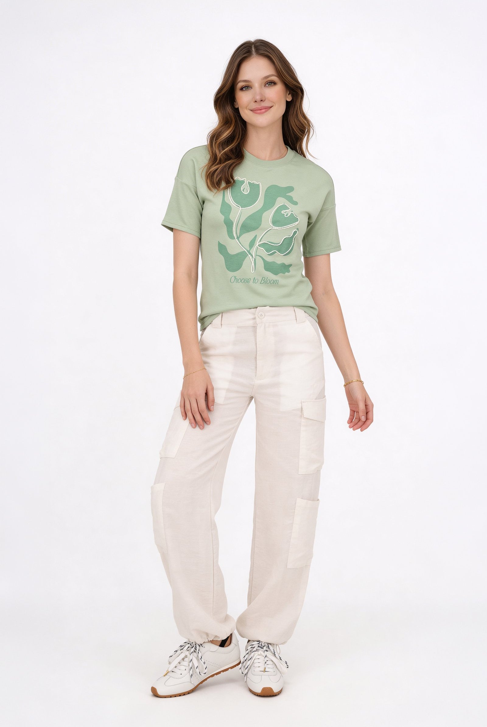 Modelo luciendo una blusa de dama casual de color verde con estampado y pantalones claros.