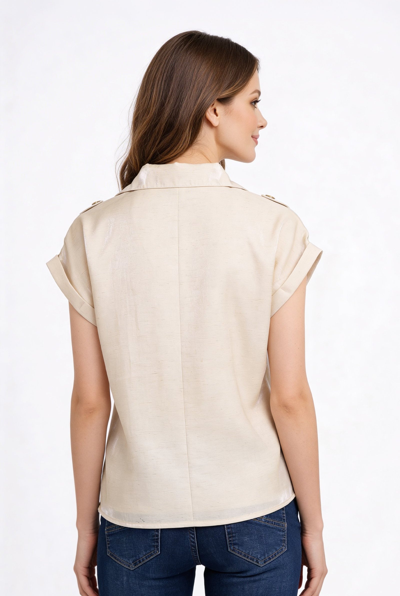 Mujer usando una blusa de dama moda de color beige, vista desde atrás, con mangas enrolladas.