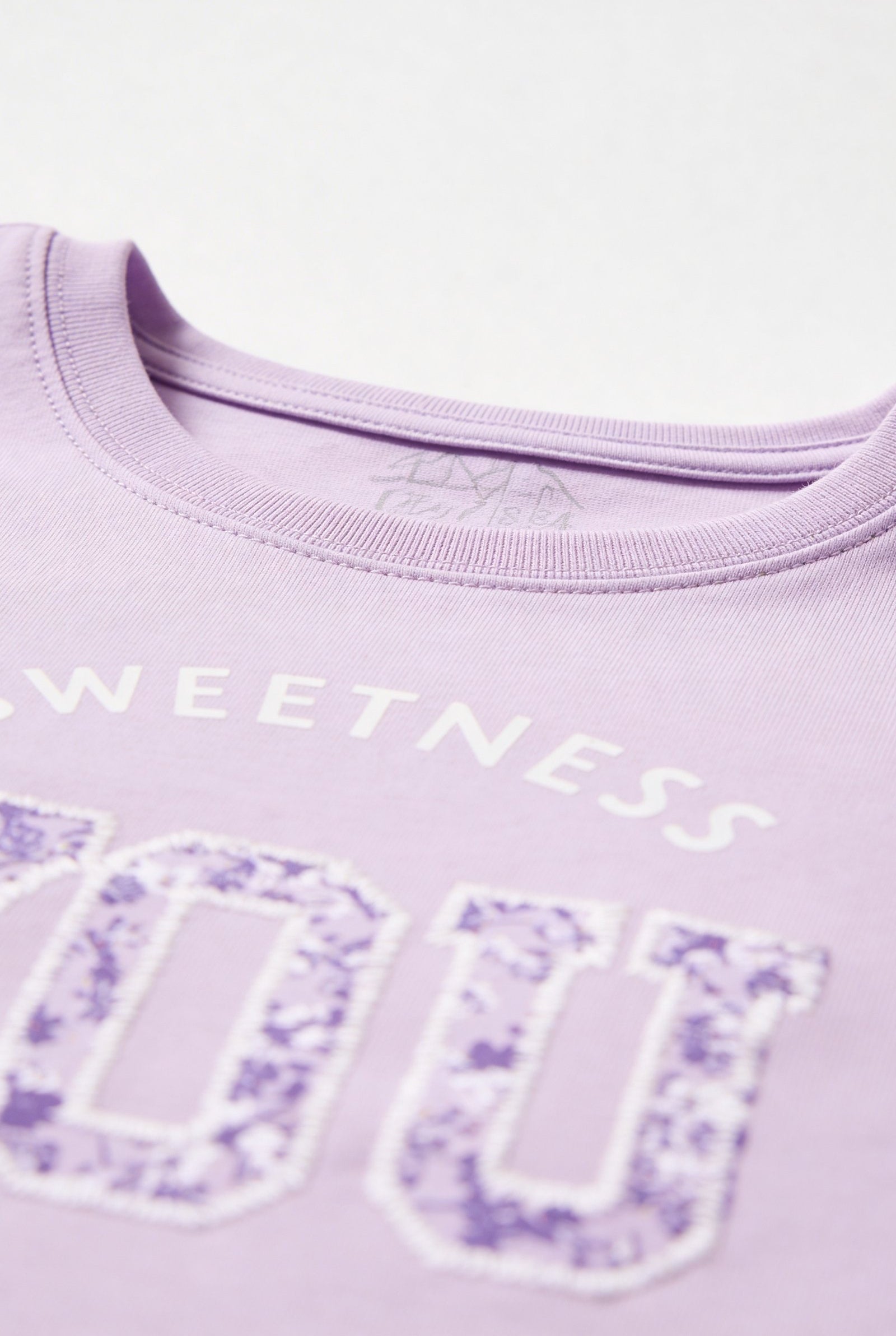 Camiseta de dama casual cuello redondo en color lila con diseño de la palabra 'Sweetness'.