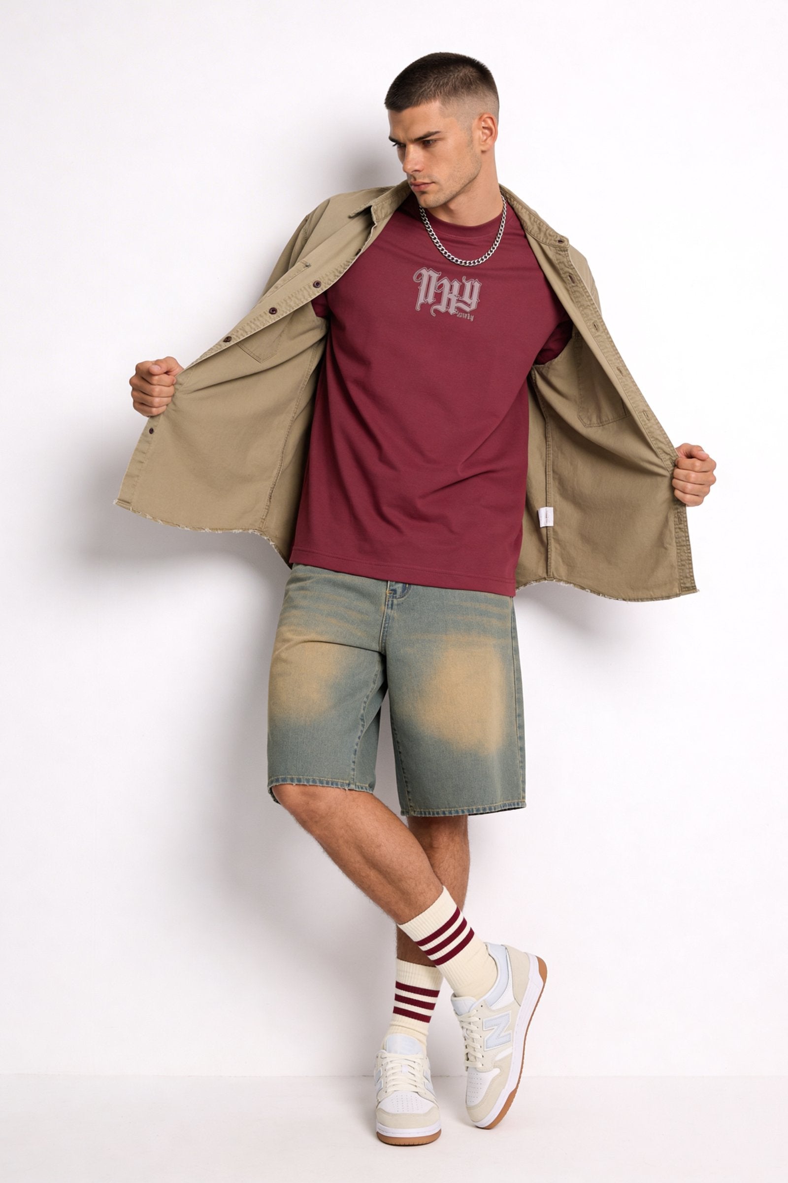 Hombre con camiseta de hombre sublimada en color burdeos, pantalones cortos y calzado deportivo.