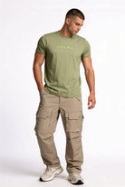 Camiseta de hombre sublimada de color verde con pantalones cargo, estilo casual y moderno.