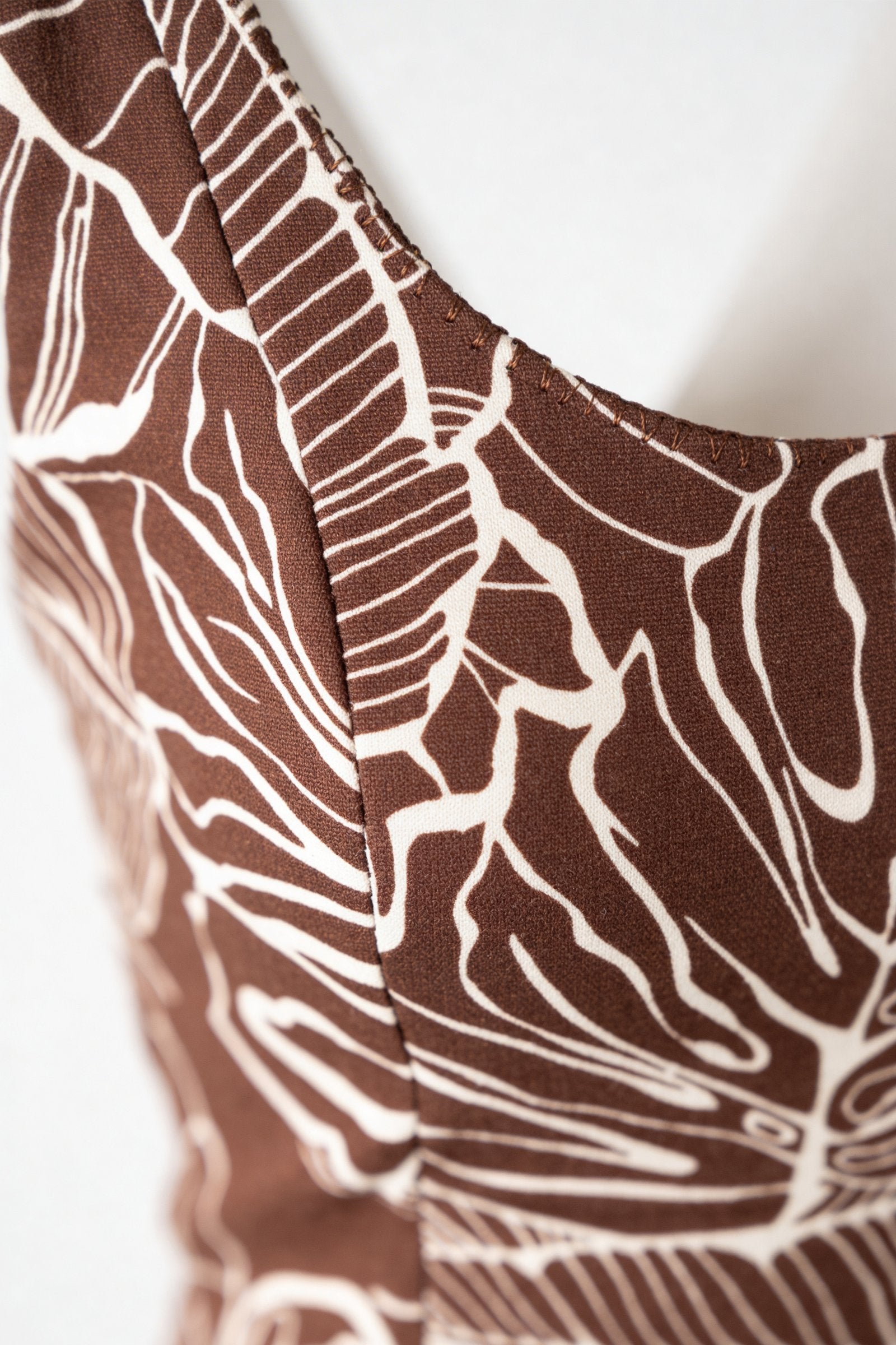 Blusa de dama moda manga sisa, detalle de la tela con diseño de hojas en tonos marrones.