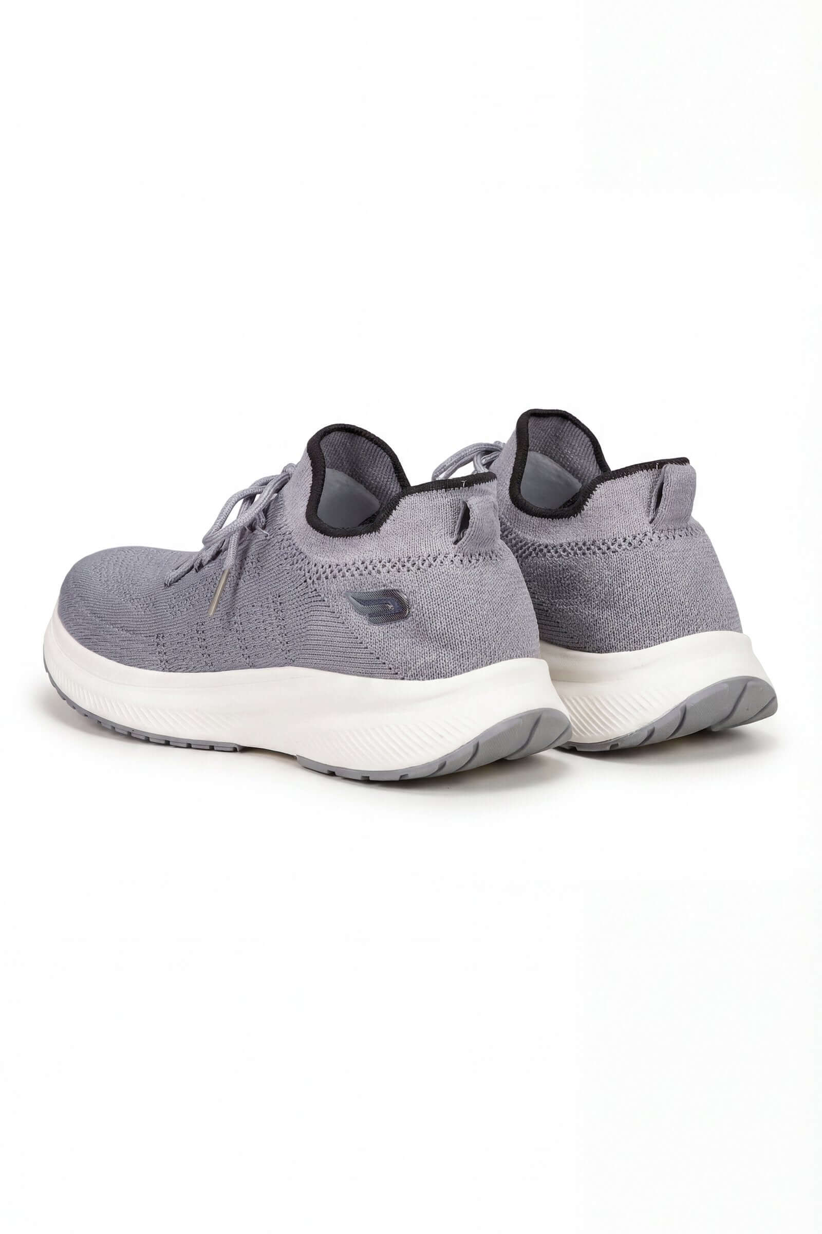 Tenis de dama deportivo en color gris, vista posterior, con diseño moderno y cómodo.