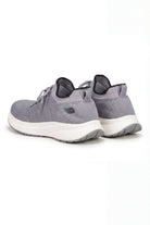 Tenis de dama deportivo en color gris, vista posterior, con diseño moderno y cómodo.