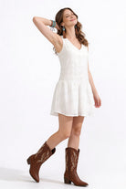 Vestido de dama de moda, vestido blanco con botas de vaquero, moda femenina.