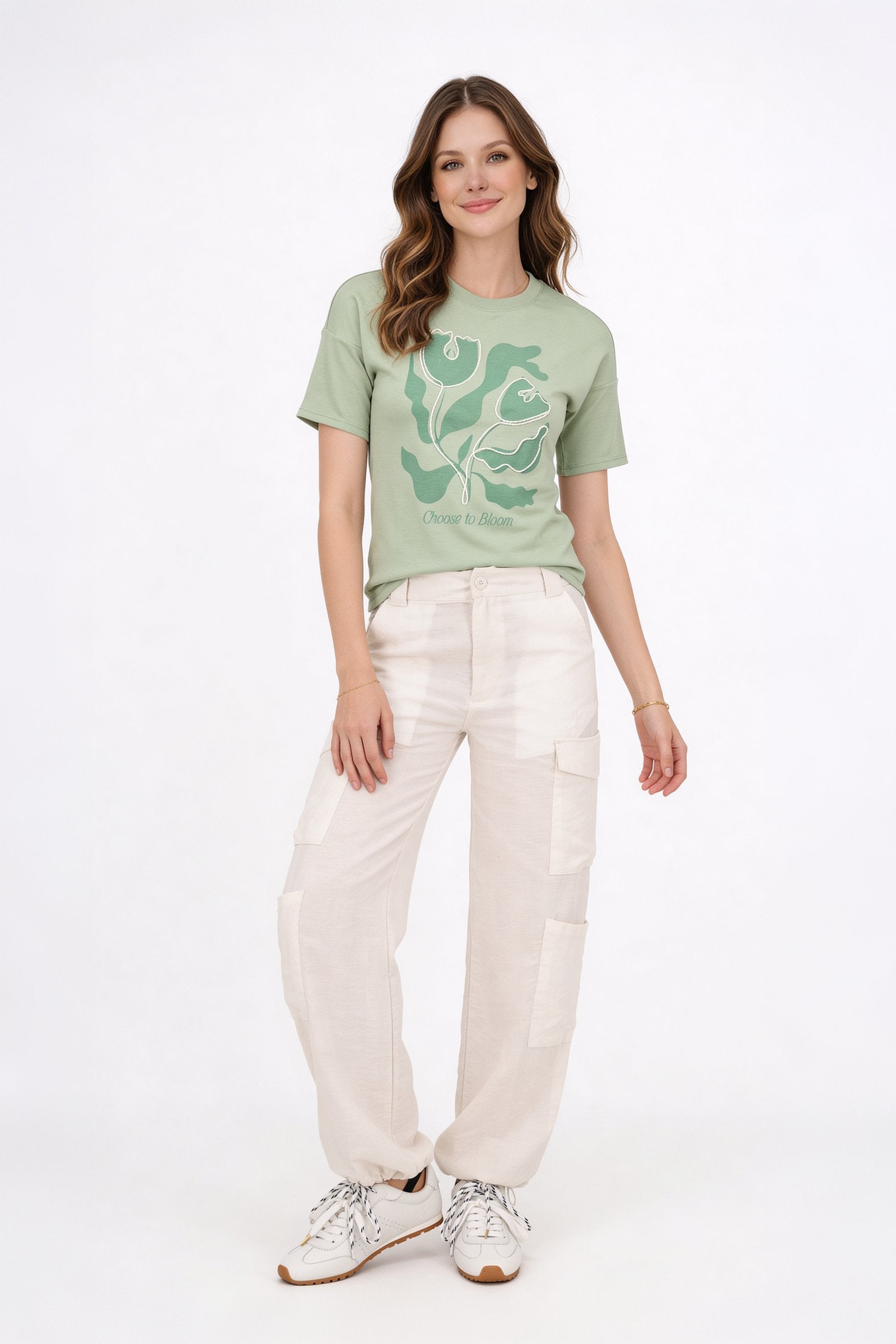 Modelo luciendo una blusa de dama casual de color verde con estampado y pantalones claros.