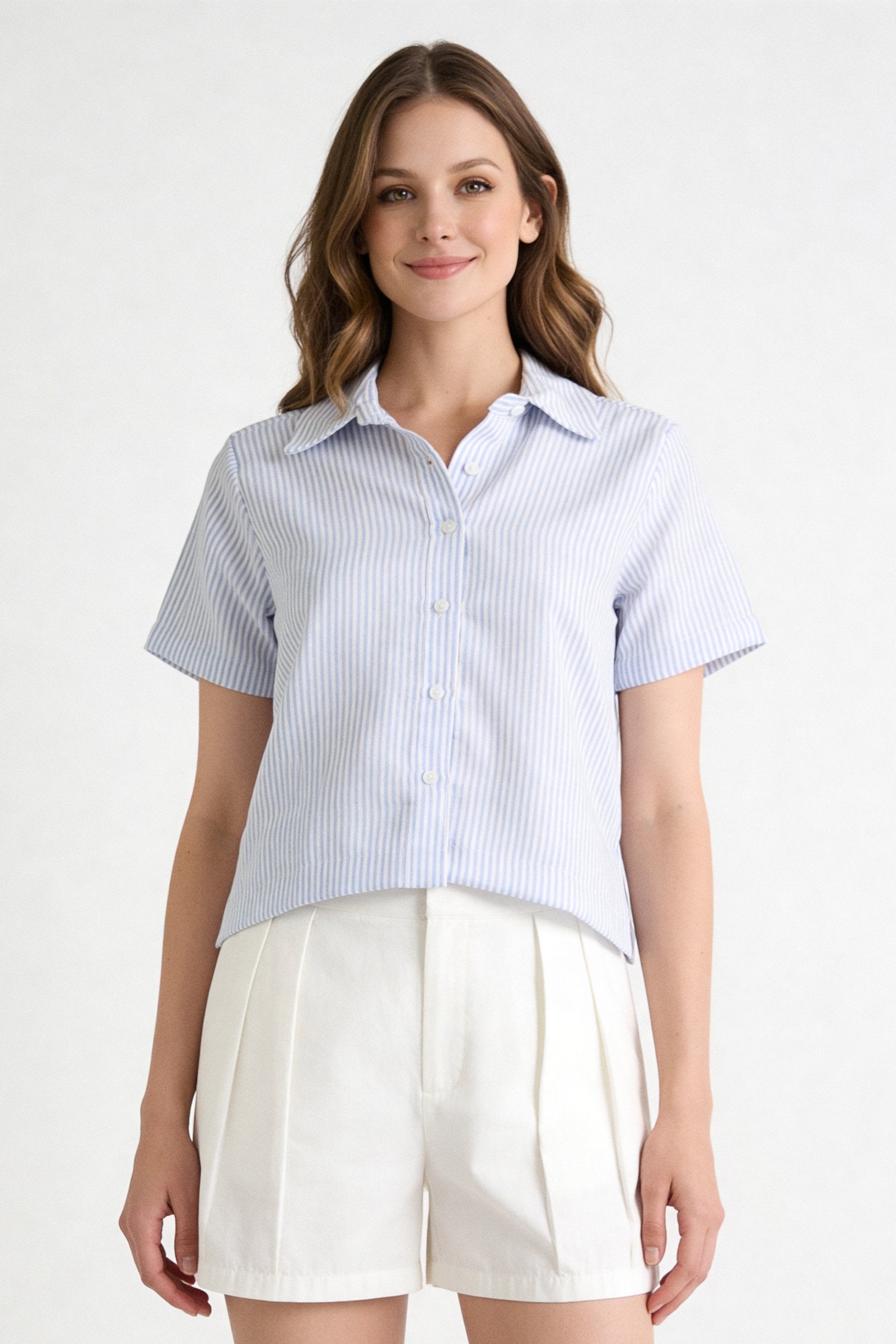 Blusa de dama moda manga corta en tonos claros, con botones y manga corta, combinada con pantalones cortos de verano.