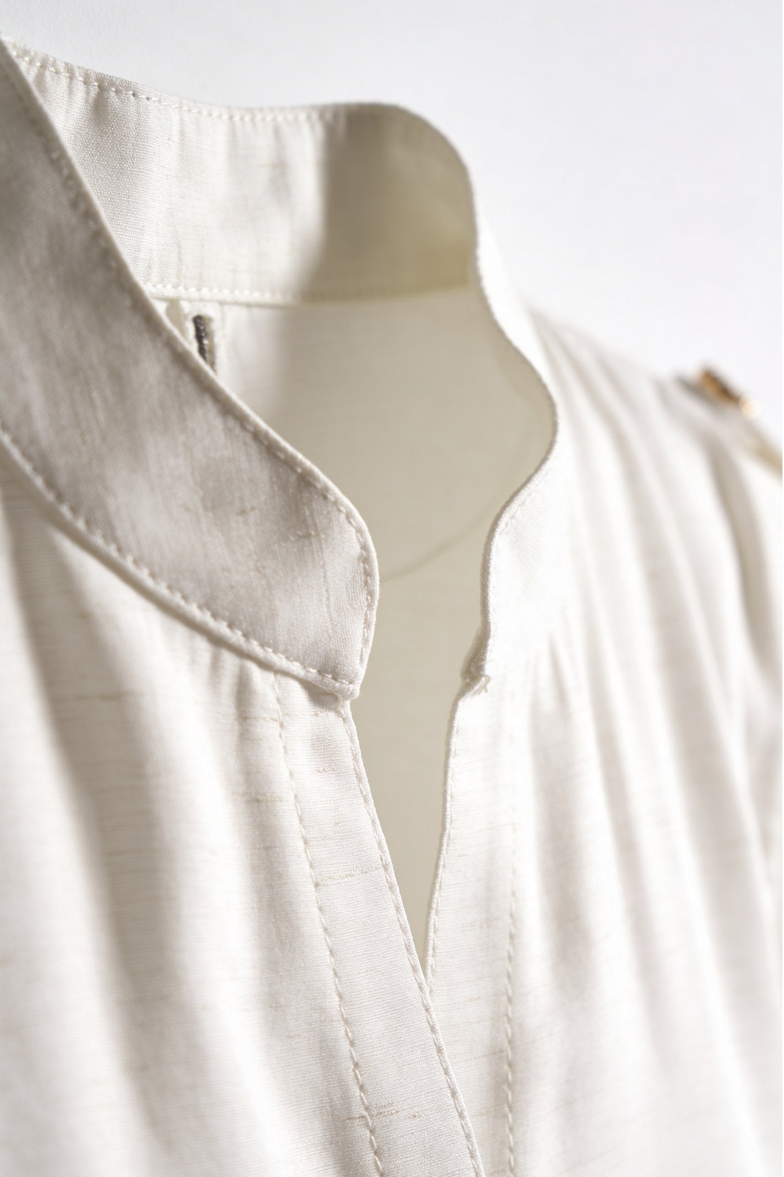 Blusa de dama moda: detalle del cuello y botón en blusa femenina elegante y moderna.