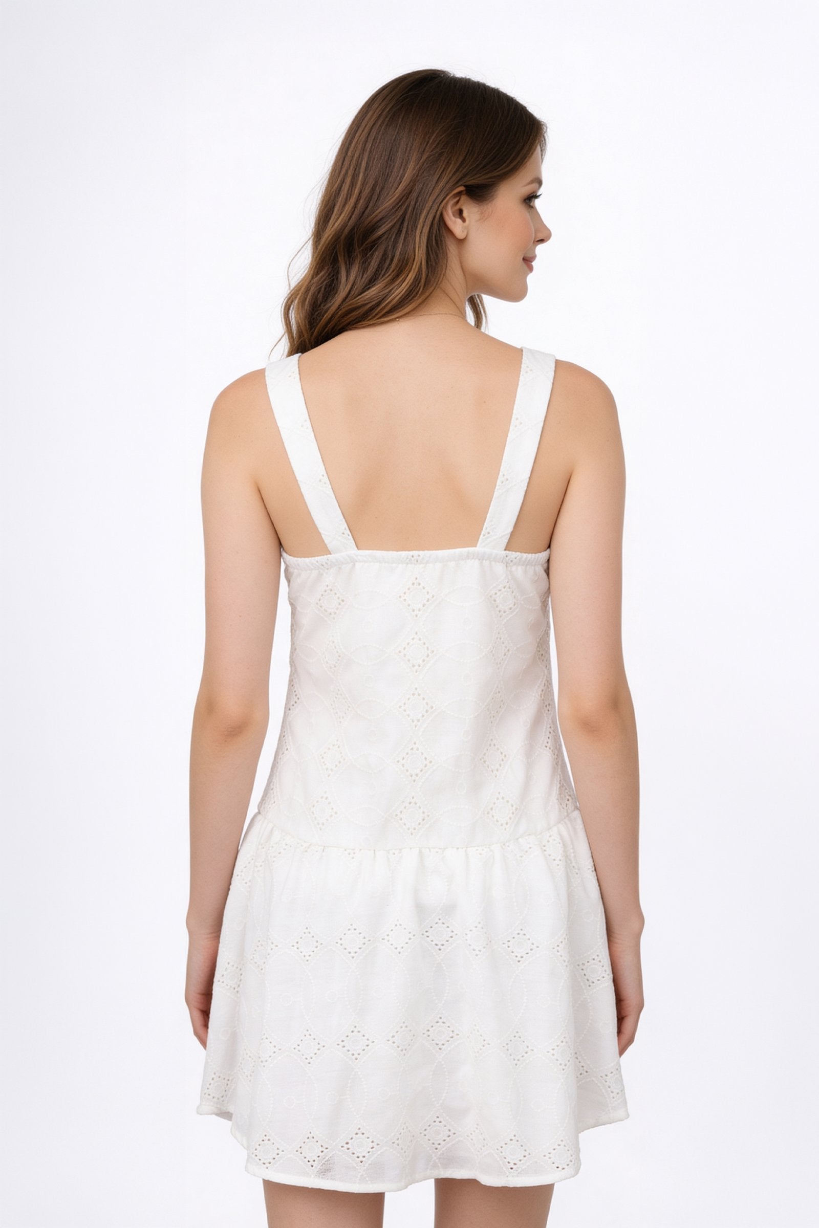 Vestido de dama de moda visto desde atrás, con tirantes anchos y falda corta en color blanco.