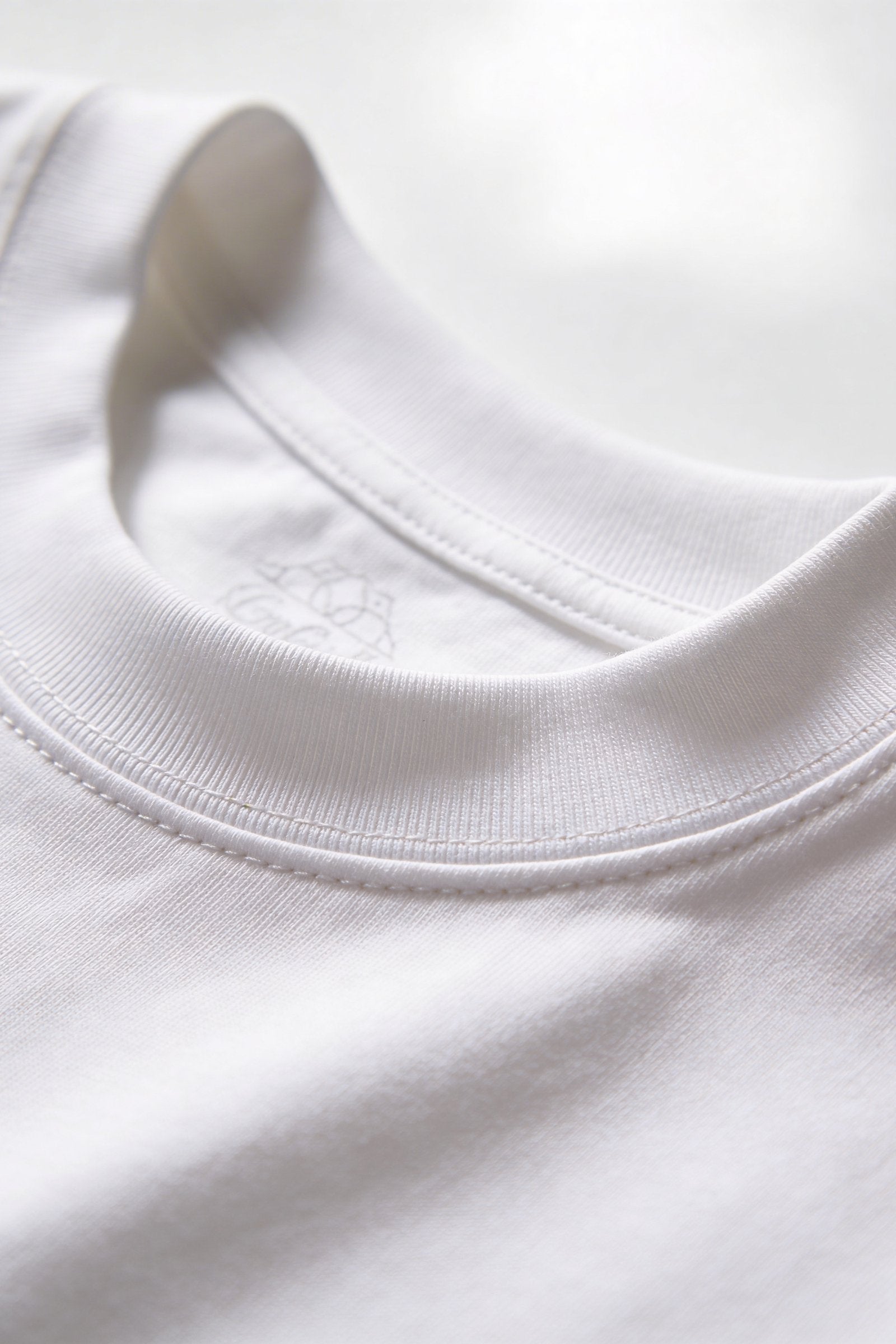 Camiseta de dama casual cuello redondo, vista del cuello de una camiseta blanca, textil suave y cómodo.