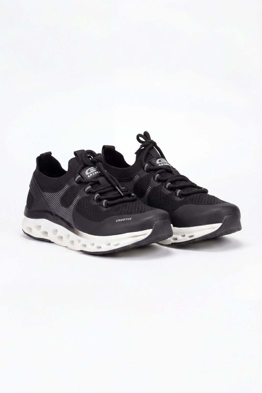 Tenis de dama deportivo en color negro con detalles en blanco y diseño moderno.