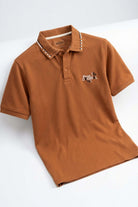 Polo de hombre de moda color marrón con detalles de diseño y logo en el pecho.