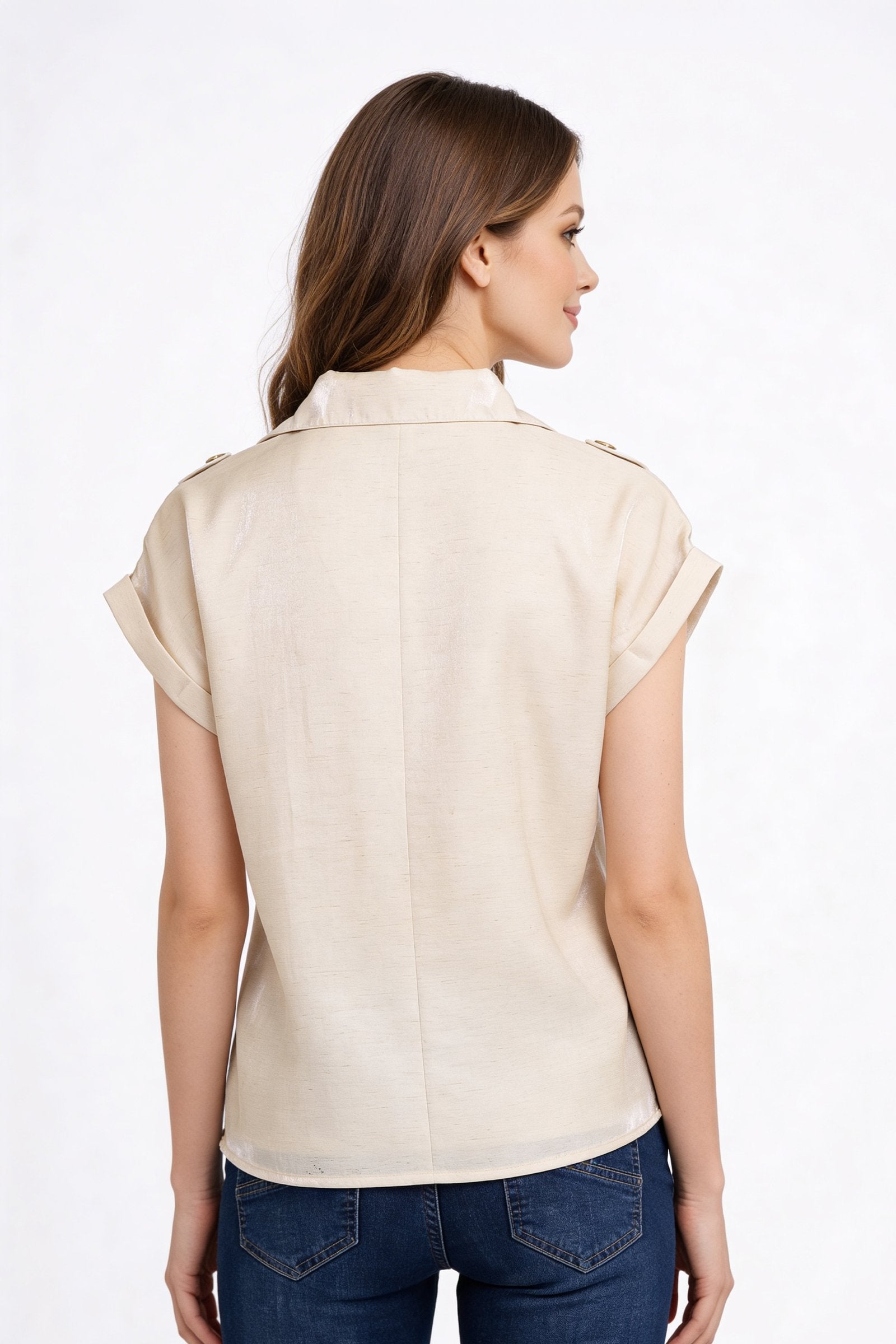 Mujer usando una blusa de dama moda de color beige, vista desde atrás, con mangas enrolladas.