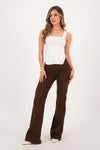 Blusa de dama básica ajustada en tejido blanco, modelo con pantalones marrones, estilo moderno y elegante.