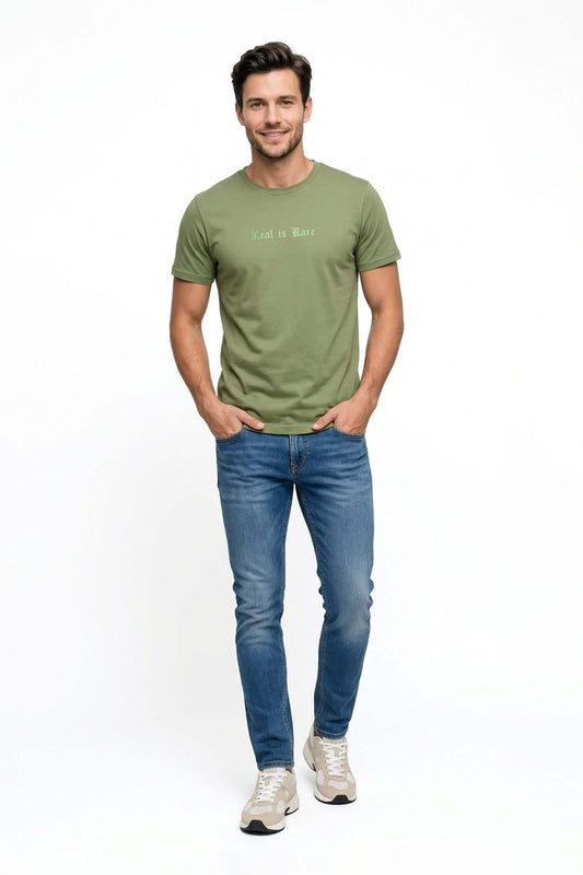 Jean de hombre básico modelo masculino con camiseta verde y pantalones azules