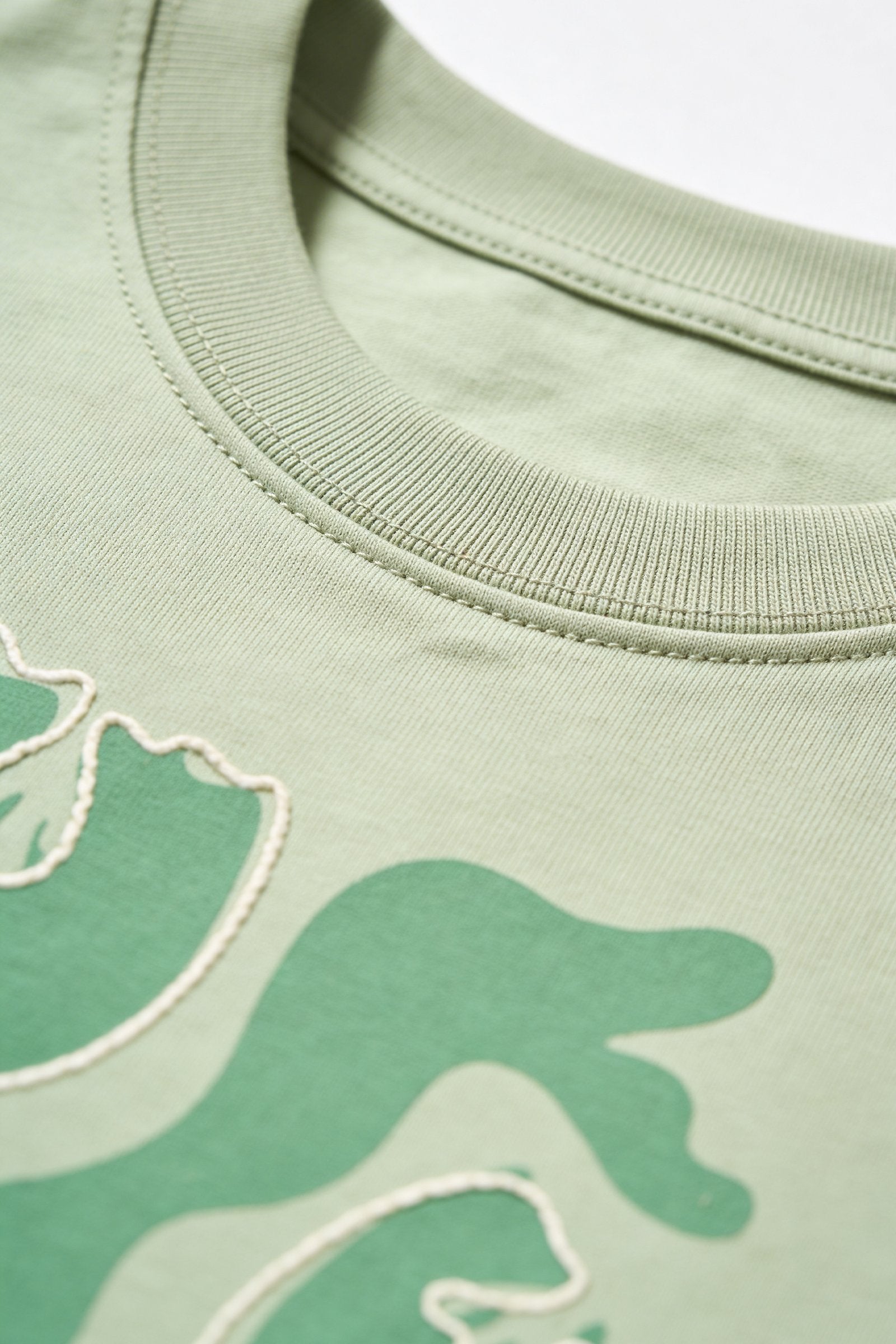 Blusa de dama casual en color verde claro, con detalles gráficos en la tela y un diseño moderno y relajado.